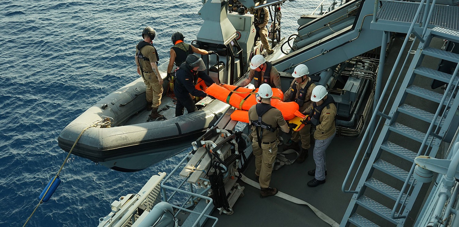 Sanitätspersonal trägt den Übungskörper wieder an Bord