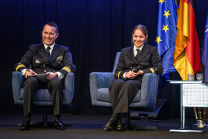 Fregattenkapitän Göran Swistek führt als Moderator durch das Programm, rechts von ihm Oberleutnant zur See Fiona Frost, Foto: Bw/Nico Theska