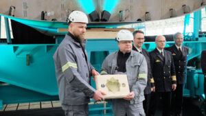 Werftmitarbeiter präsentieren Gedenktafel: Andre Loth und Heiko Schulz zeigen die eingebrachte Gedenkplatte zur Kiellegung der neuen Flottendienstboote. Foto: HSC