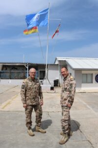 Der Inspekteur der Marine Vizeadmiral Jan-Christian Kaack mit dem Commander Task Force Maritime (MTF) Flottillenadmiral Richard Kesten vor der Flagge der UN. 